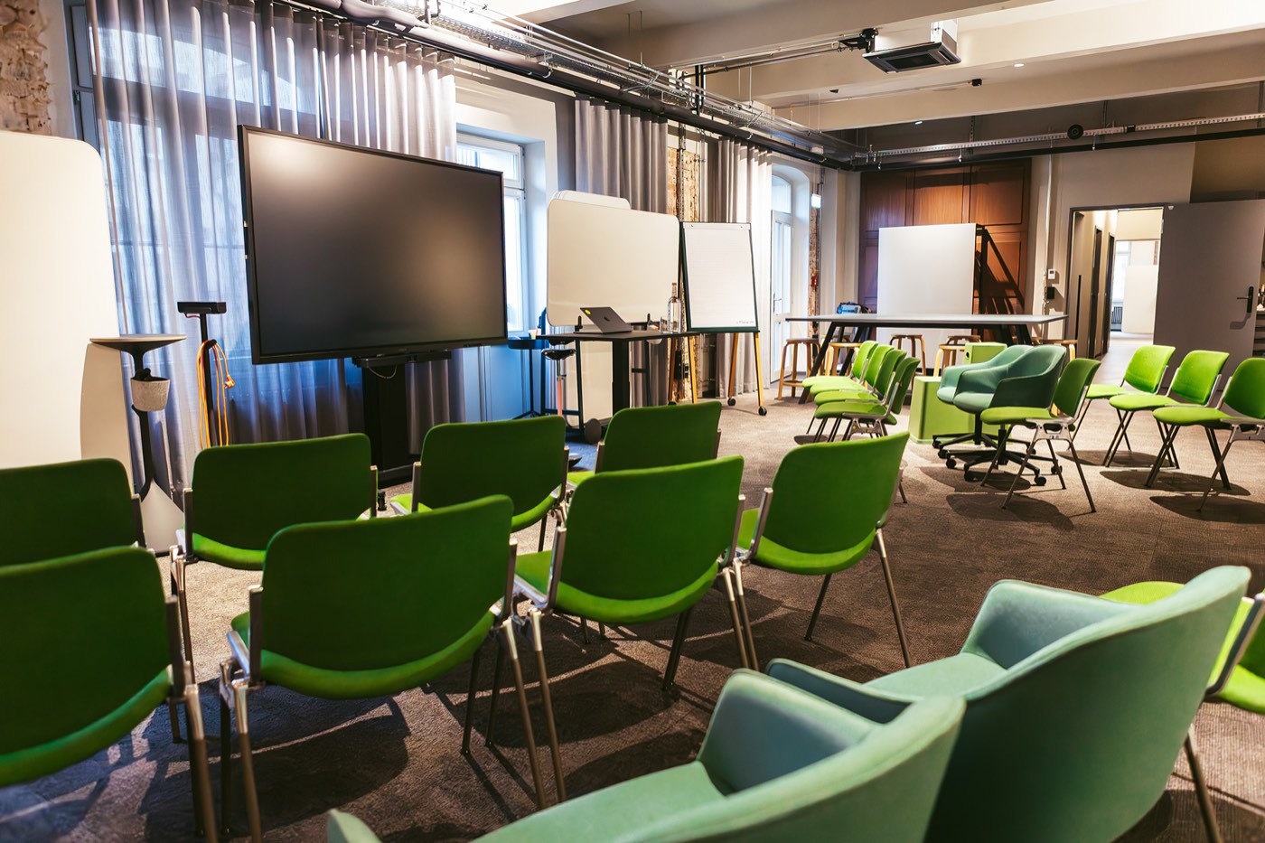 Bestuhlung vor großem Screen und Whiteboards im Atelier des club199